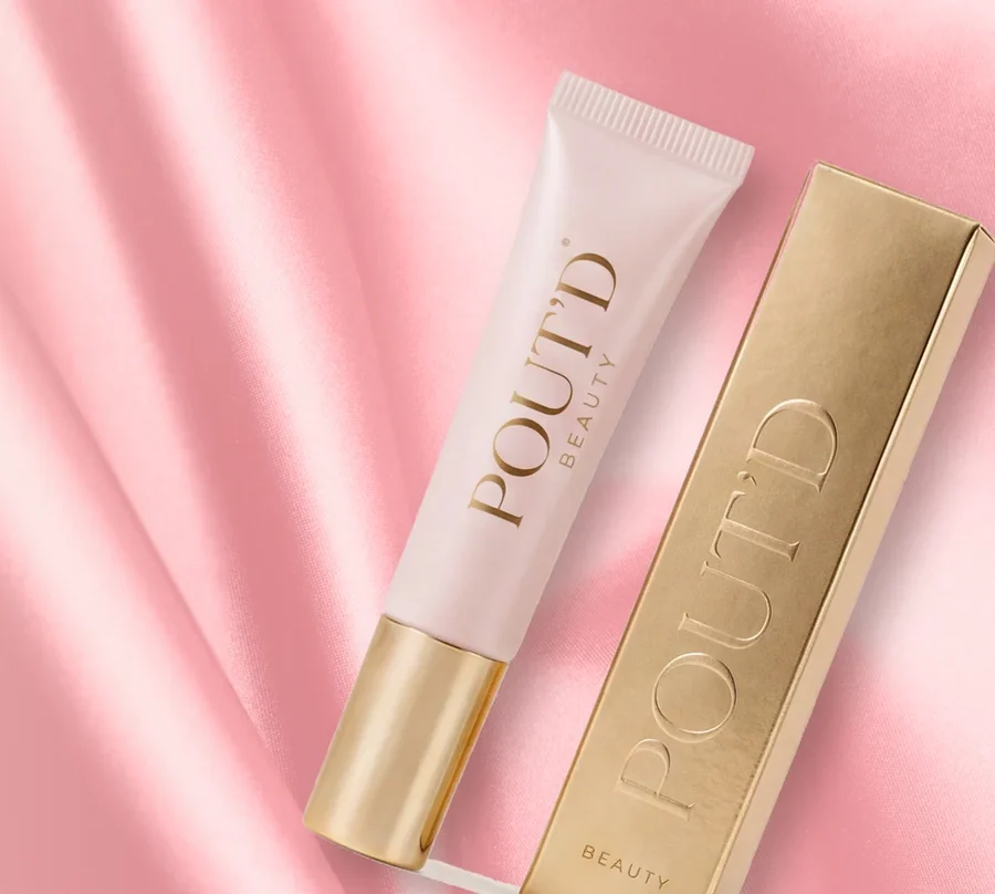 Pout'd lip plumper — pink tube and gold box styled on draped pink silk